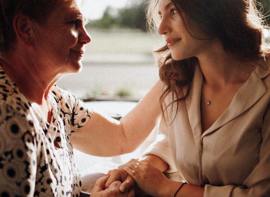Una giovane donna tiene per mano una signora anziana