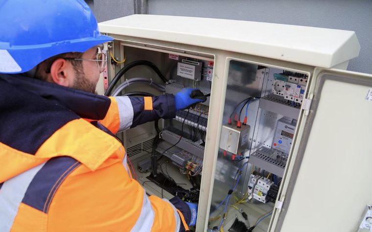 Un elettricista al lavoro su un quadro elettrico